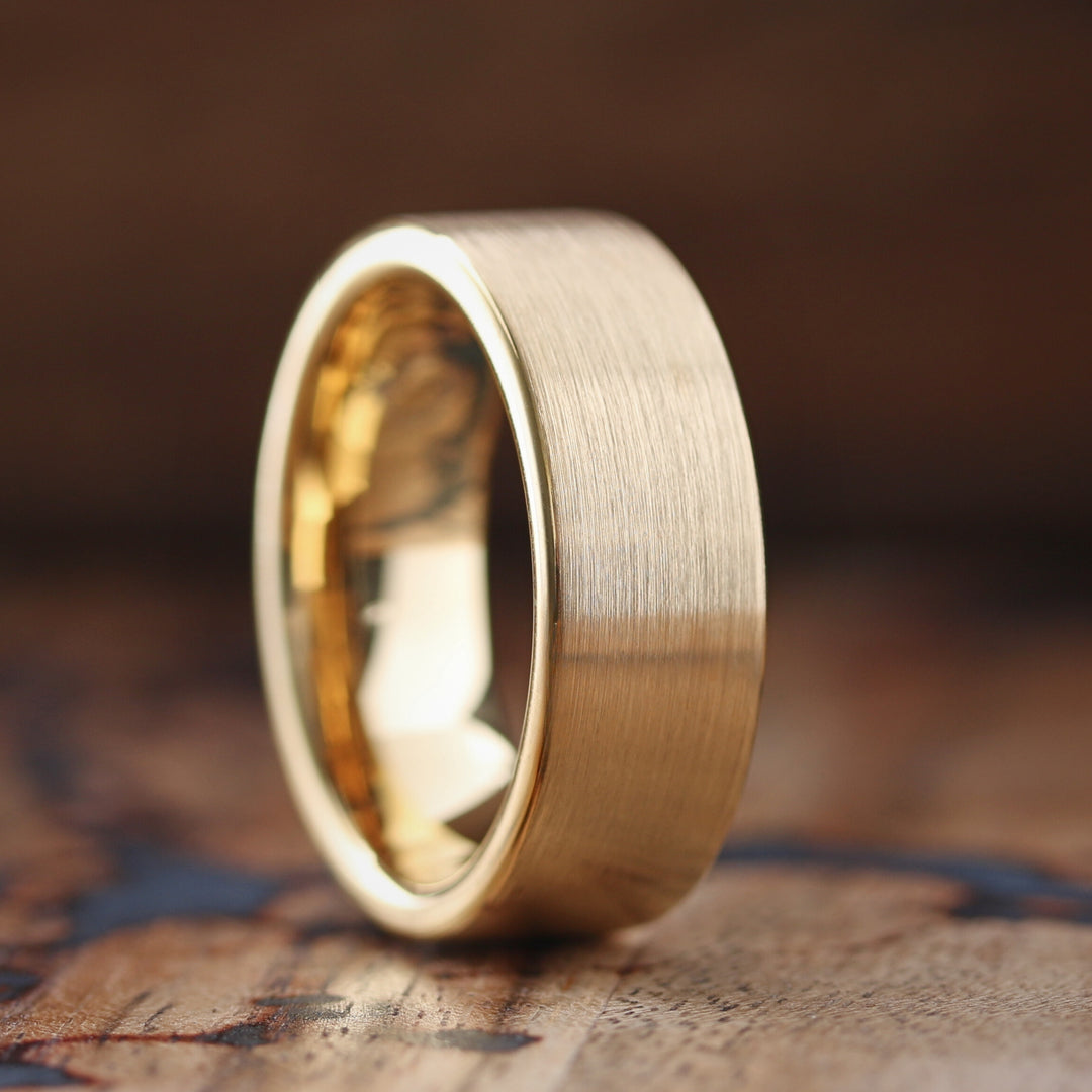 This rugged yellow gold tungsten wedding band features a brushed textured top, polished gold sides, and a polished interior, embodying the fusion of resilience and elegance. Crafted for the man who values both tradition and boldness, the Golden Forged stands as a testament to your unbreakable bond. Wear it with pride, knowing it represents a promise as enduring as the metal it's made from.